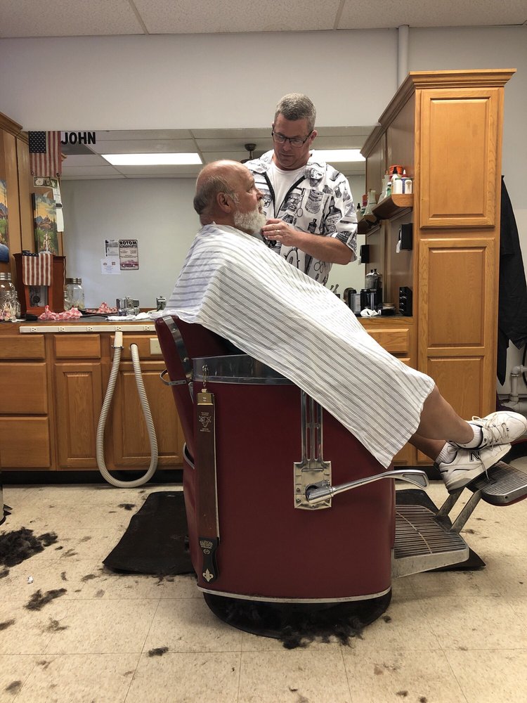 John tending to a customer in the original Willard Barber Shop chair