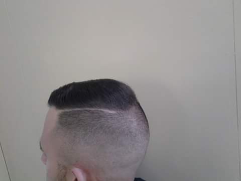 Side view of a short haircut with a defined part
