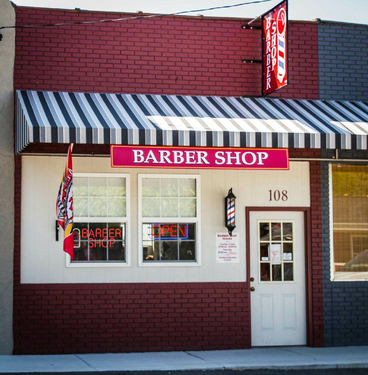 Willard Barber Shop entrance at 108 East Jackson Street, with striped awning and original shop sign